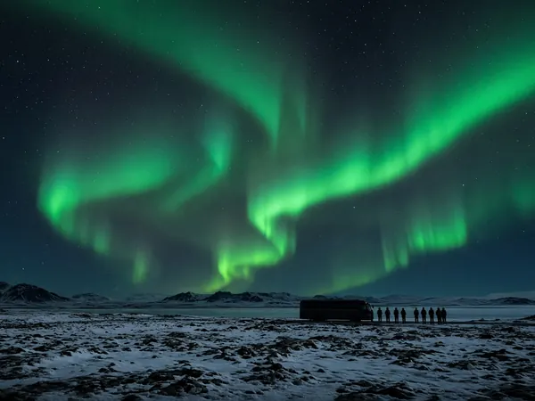 Green northern lights over a snowy plain at night, with a tour bus and a few people far away